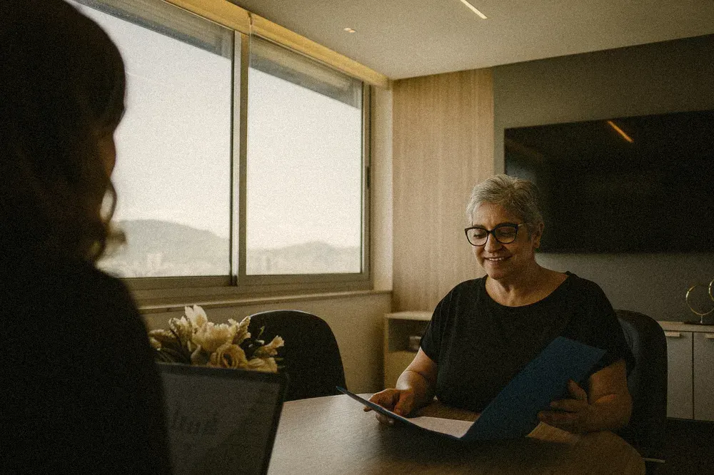 Dona de clínica conferindo documentos em reunião